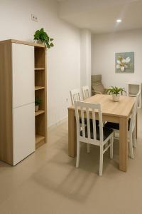 een keuken met een tafel, stoelen en een koelkast bij Alojamiento Baeza California 4A in Baeza