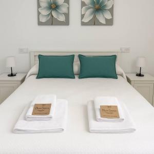 een wit bed met twee borden erop bij Alojamiento Baeza California 4A in Baeza +17 foto's