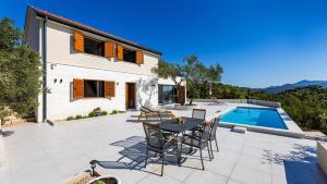 a patio with a table and chairs next to a pool at Villa Teuta by Villas Guide in Baćina