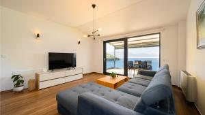 a living room with a blue couch and a television at Villa Dida Bozo by Villas Guide in Blace
