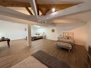 a large room with two beds and a table at La Douce Parenthèse in Loudun