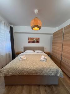 een slaapkamer met een bed met twee handdoeken erop bij Central-home in Târgu Jiu