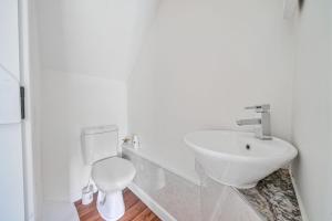a white bathroom with a sink and a toilet at Mill View in Harpley +20 photos