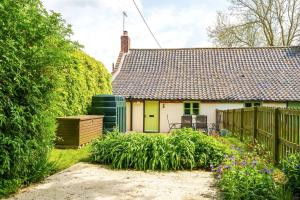a cottage with a fence and a garden at Mill View in Harpley