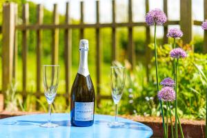a bottle of wine and two wine glasses on a table at Mill View in Harpley