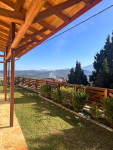 a wooden fence with a view of the mountains at Το Ράντζο του Λυμπέρη in Dhávlia
