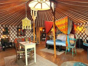 a bedroom in a yurt with a bed and a table at 2 CUORI E 1 YURTA Glamping in Tuscany - Adults Only in Asciano