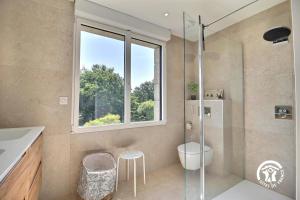 a bathroom with a shower and a toilet and a window at Ty bayon in Belz +53 photos