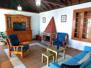 een woonkamer met een bank en een open haard bij Peluquina in Barlovento