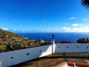 a white fence with a view of the ocean at Peluquina in Barlovento