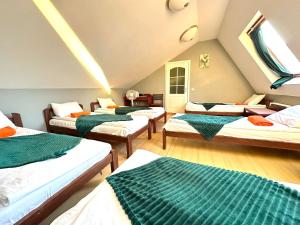 een zolderkamer met 4 bedden en een bank bij I&A Residence Humala in Tallinn