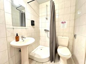 een witte badkamer met een wastafel en een toilet bij I&A Residence Humala in Tallinn +15 foto's