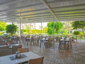 een restaurant met tafels en stoelen en een tafeltennistafel bij Halıcı Hotel Marmaris in Marmaris