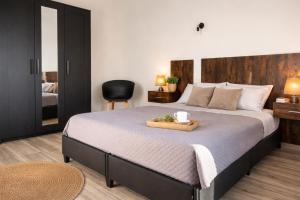 une chambre avec un grand lit avec une tête de lit en bois dans l'établissement residence Sant'Anna i4MORI, à SantʼAnna Arresi