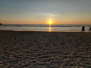 a group of people walking on the beach at sunset at The love shack atChaba in Ko Lanta