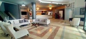 a large living room with white furniture and a kitchen at Vanna Hotel Spa in Hamamözü