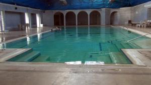 a large swimming pool with green water in a building at Vanna Hotel Spa in Hamamözü