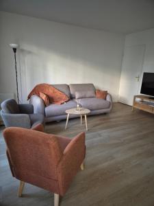 een woonkamer met een bank en een tafel bij Appartement cosy près du RER in Chessy