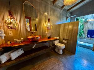 ein Badezimmer mit Waschbecken, Toilette und Spiegel in der Unterkunft Casa Preguiça Corumbau in Corumbau + 84 Fotos