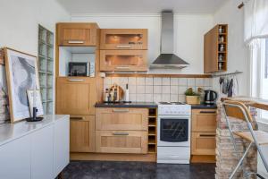 une cuisine avec des armoires en bois et un four à plaques de cuisson dans l'établissement Homey Stay, à Halmstad