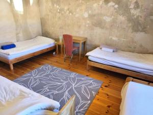 a room with two beds and a table and a chair at Grosses Privatzimmer mit Altbau-Charme in Leipzig +2 photos