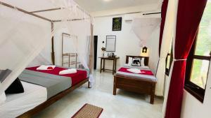 a bedroom with two beds with red and white sheets at Shaa Home Stay Sigiriya in Sigiriya +33 photos