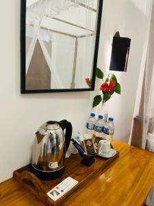 a wooden table with a tea kettle and a mirror at Shaa Home Stay Sigiriya in Sigiriya
