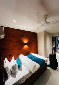 een slaapkamer met een groot bed met een bakstenen muur bij ALOHA DIVINE GANGES APARTMENTS with INFINITY POOL in Rishīkesh