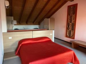 a bedroom with a bed with a red blanket on it at Residence Le Volte Apartments in Parma