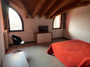 a bedroom with a red bed and a television at Residence Le Volte Apartments in Parma