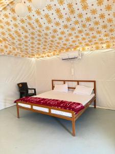 ein Bett in einem Zimmer mit einer blumengeschmückten Decke in der Unterkunft Stayguru Patgar Tent in Dhordo