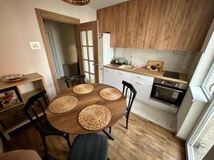 una cucina con un tavolo e sedie in una stanza di Tilia a Zaječar