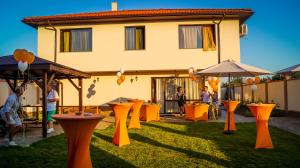 un groupe de tables et de parapluies dans une cour dans l'établissement Guest House Meridi, à Preseltsi