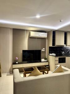 a living room with a couch and a tv at Surin Beach View Phuket in Ban Lum Fuang