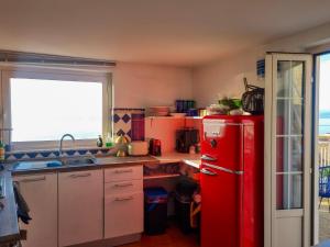 a red refrigerator in a kitchen with a window at Casa Azzurra in Pizzo
