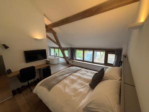 a bedroom with a bed and a desk and a tv at EBURON estate Boutique B&B in Diets-Heur +39 photos