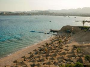 an aerial view of a beach with chairs and umbrellas at Movenpick Resort Sharm El Sheikh in Sharm El Sheikh