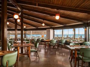 艾因苏赫纳艾尔索克纳瑞享酒店 的餐厅里有桌椅和窗户。