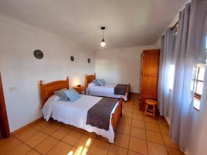 een hotelkamer met twee bedden en een raam bij Peluquina in Barlovento