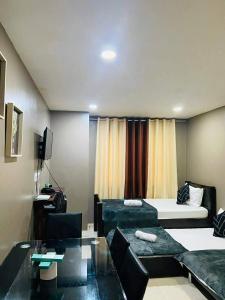 a living room with a couch and a bed at The Highland Condotel in Baguio