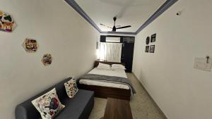een kleine kamer met een bed en een bank bij The Nook in Pondicherry