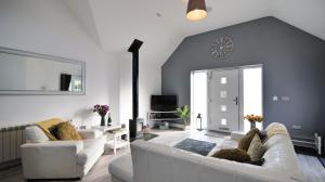a living room with two white couches and a tv at Hoxne Cottages in York