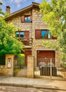 a stone house with a gate and a garage at Casa de Muntanya per desconectar in San Julián de Cerdanyola