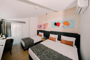 une chambre d'hôtel avec deux lits et un bureau dans l'établissement Laren Sea Side Hotel Spa, à Antalya