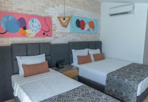 Cette chambre comprend 2 lits et des peintures murales. dans l'établissement Laren Sea Side Hotel Spa, à Antalya