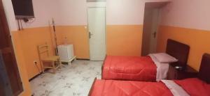 ein Schlafzimmer mit einem roten Bett und einer Tür in der Unterkunft Hotel el djawhara in Melika