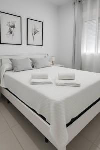 a white bed with two towels on top of it at Alojamiento Baeza California 2B in Baeza +8 photos