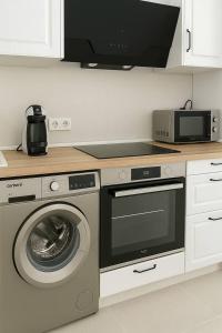 a kitchen with a washing machine and a microwave at Alojamiento Baeza California 2B in Baeza