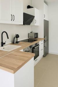 a kitchen with white cabinets and a sink and a stove at Alojamiento Baeza California 2B in Baeza +8 photos