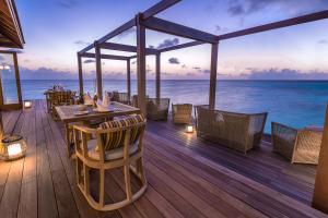 a restaurant with tables and chairs on the beach at Hurawalhi Island Resort in Kuredu
